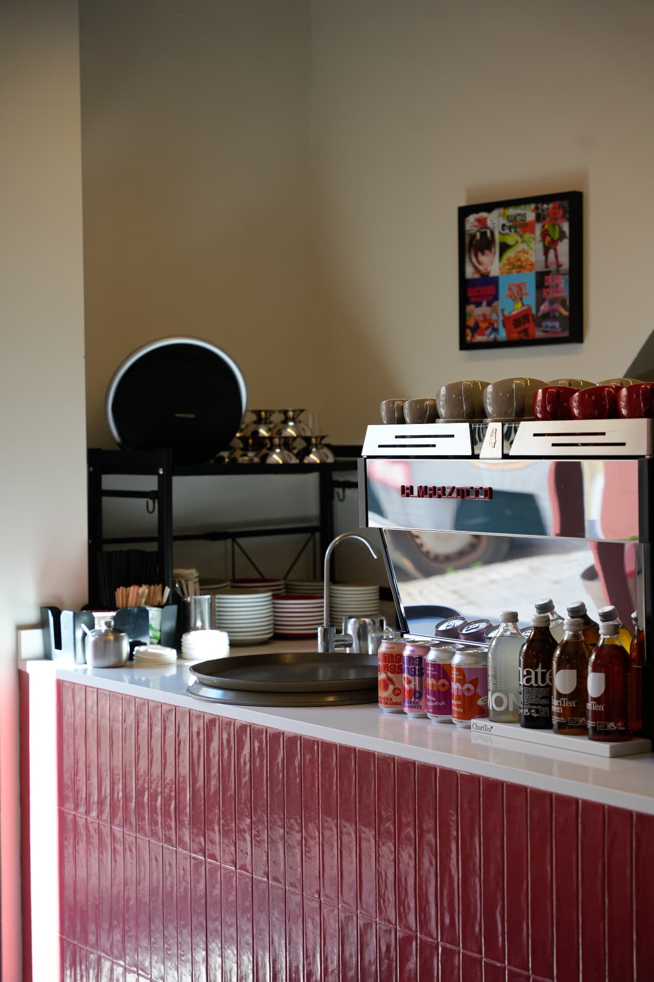 Barra de azulejos rosas con la máquina de café La Marzocco